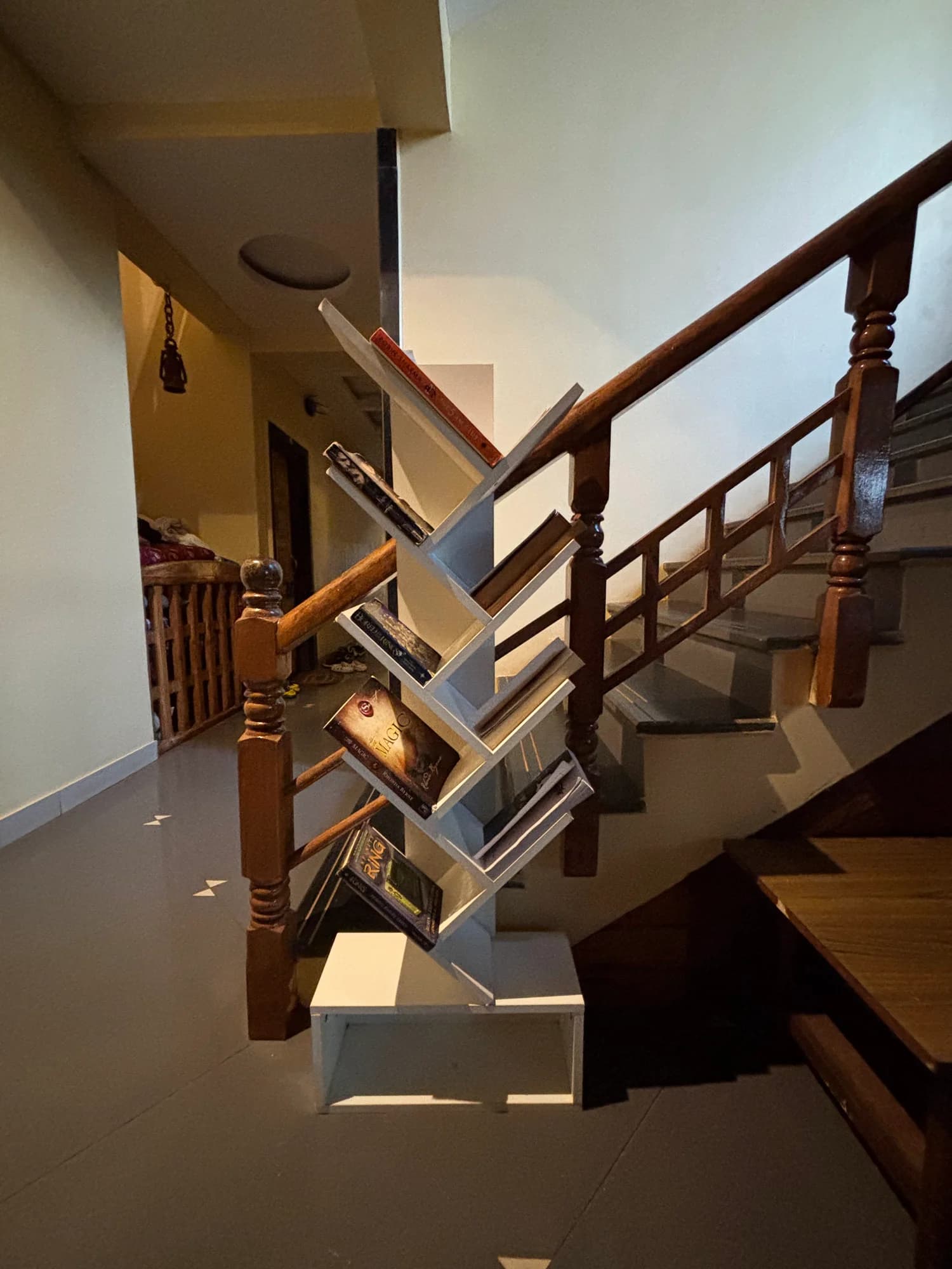 A wooden staircase with a geometric sculpture near its railing.