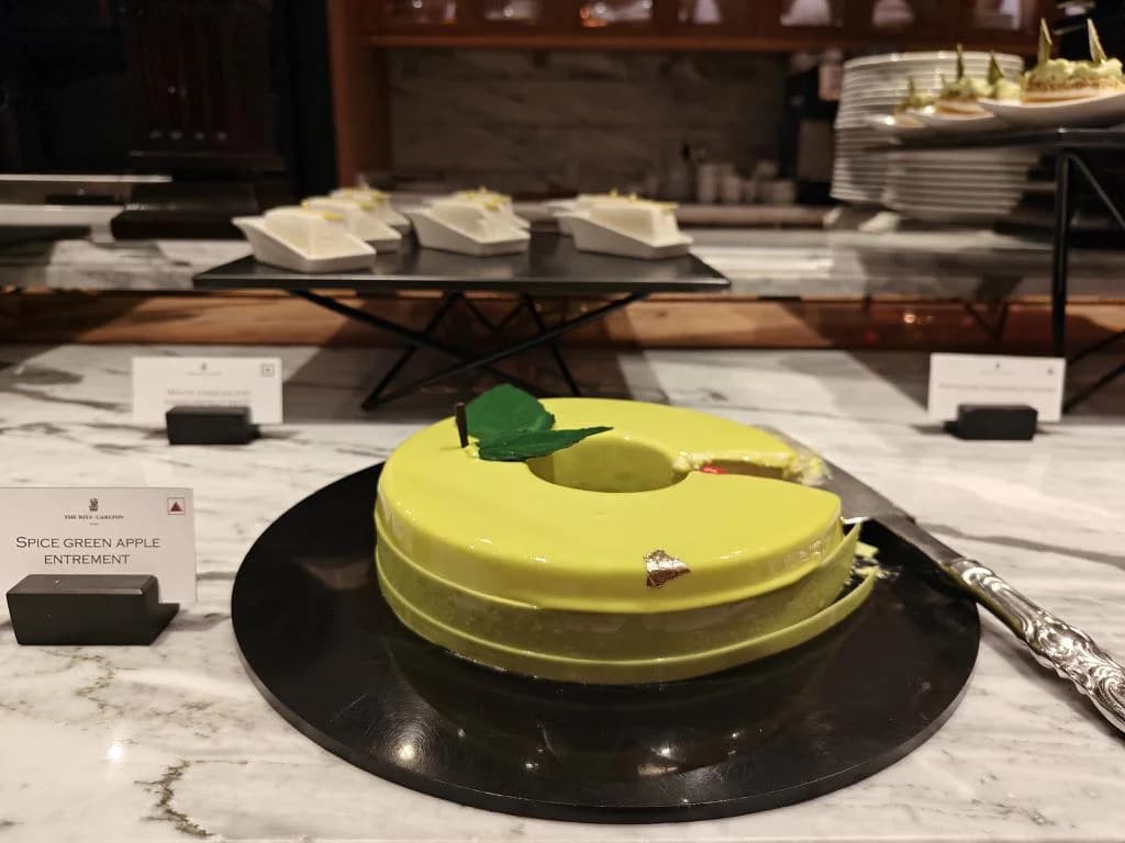 A glossy green cake displayed at a dessert counter.
