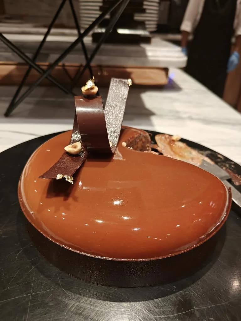 A round chocolate cake topped with a sculptural chocolate decoration.
